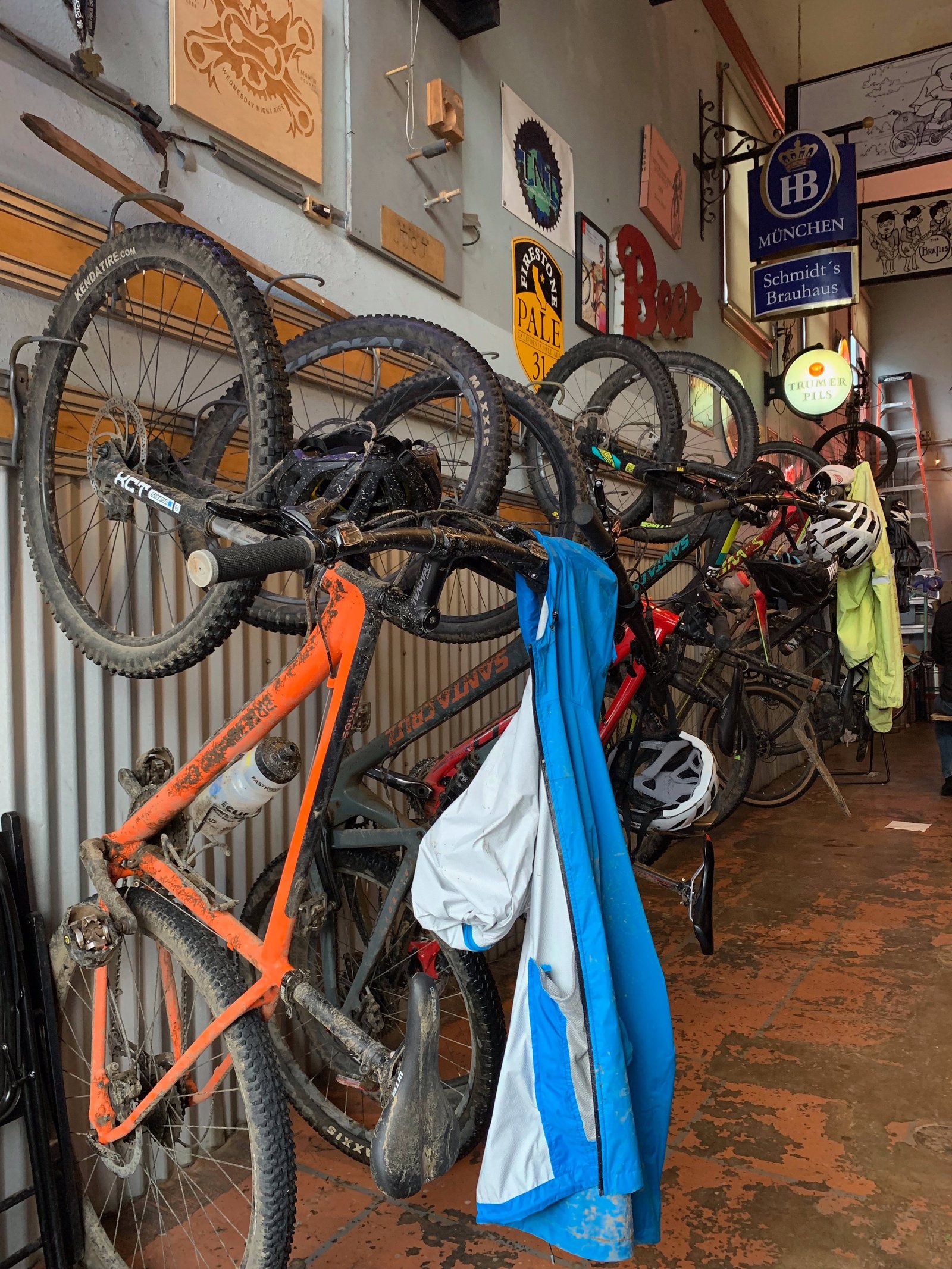 A wall of muddy mountain bikes racked inside Gestalt Haus